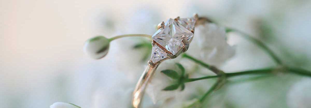 Engagement ring with vibrant flowers in the background