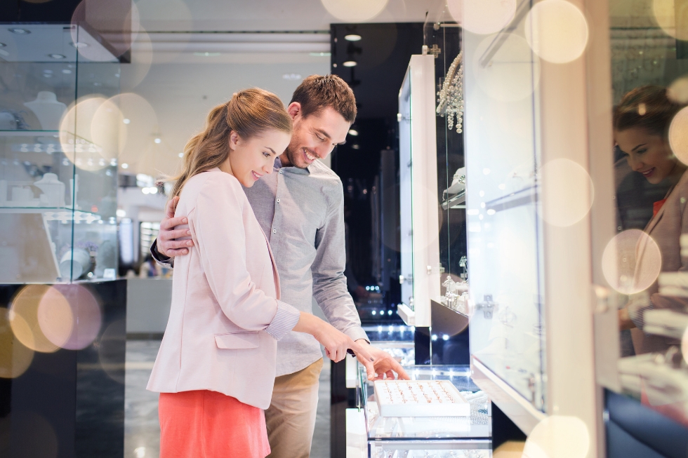 4 Couple shopping for engagement rings in jewelry store.