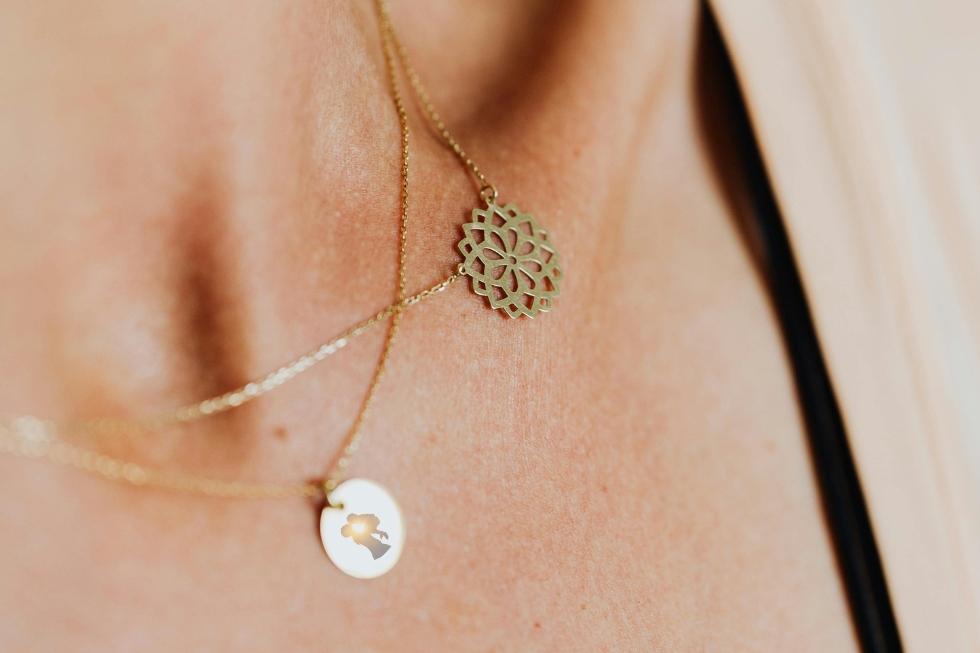 3 Layered gold necklaces with floral, mother charm.