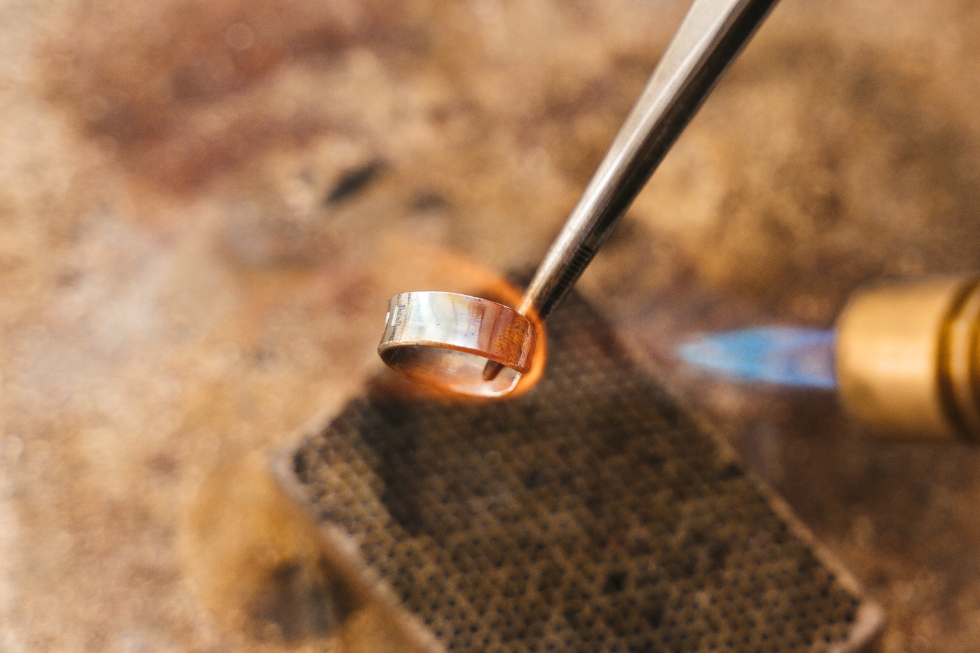 4 Jeweler heating a metal ring with a torch.