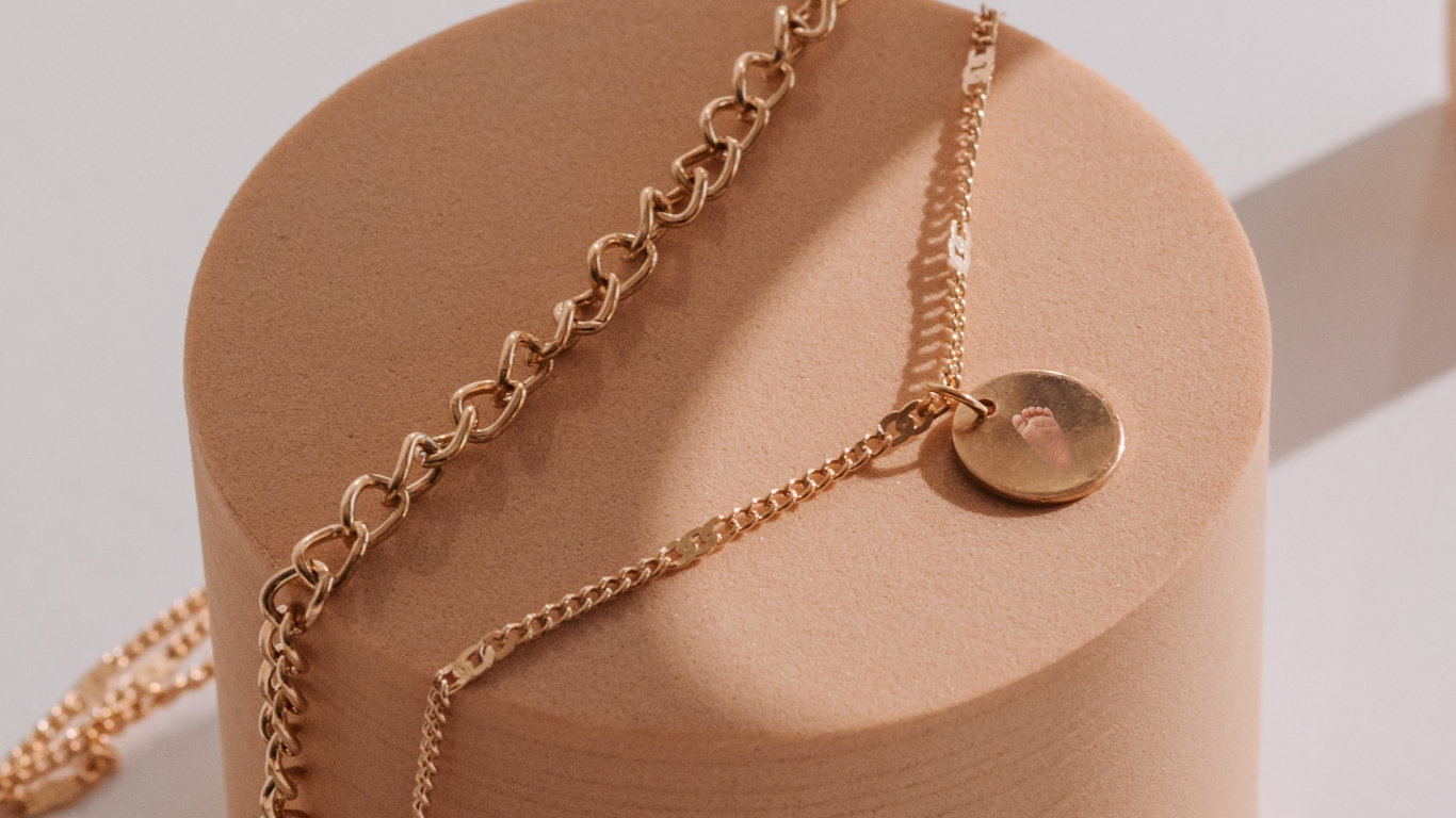 Gold necklace with baby footprint pendant.