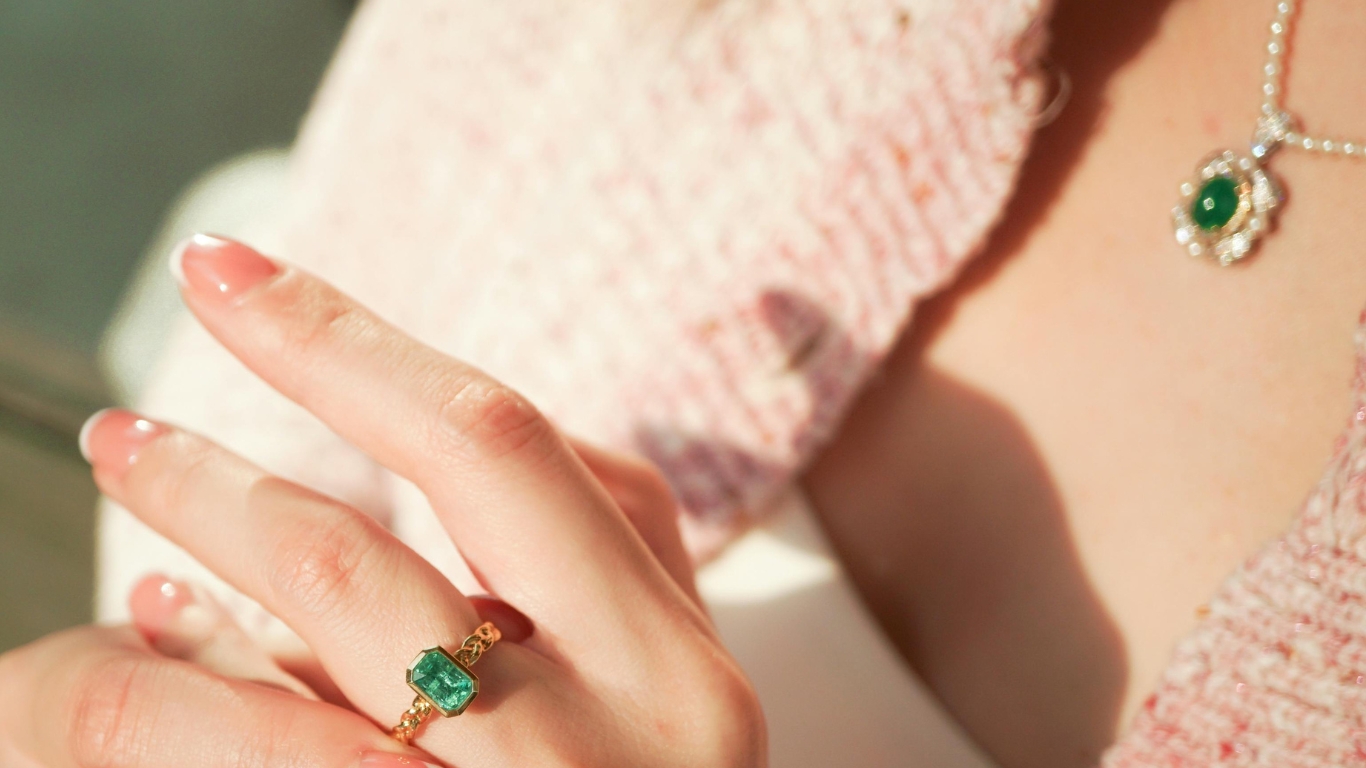 Vintage-inspired gold ring with a rectangular emerald-cut green gemstone.