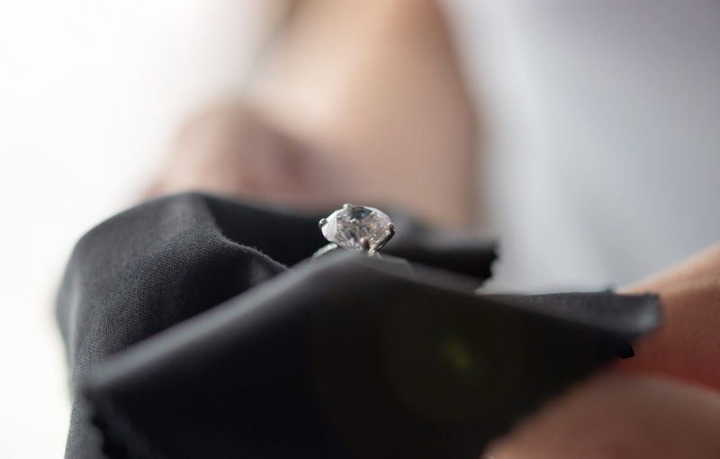 Polishing solitaire diamond engagement ring.