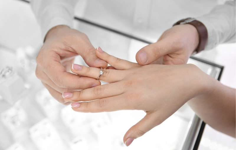 Customer purchasing engagement ring in store.