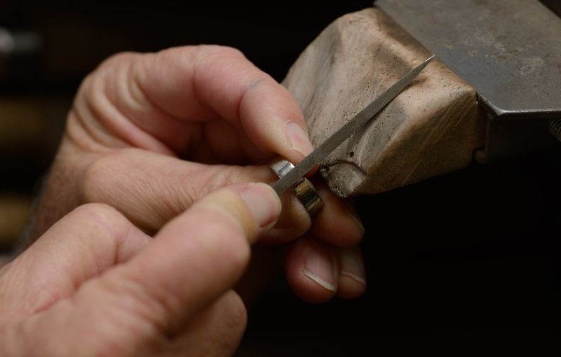 Craftsman filing ring on workbench.
