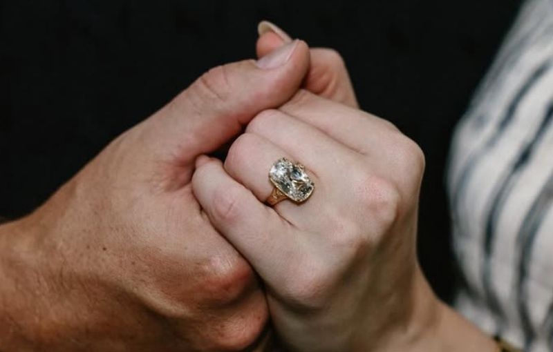 Close-up hands with engagement ring.