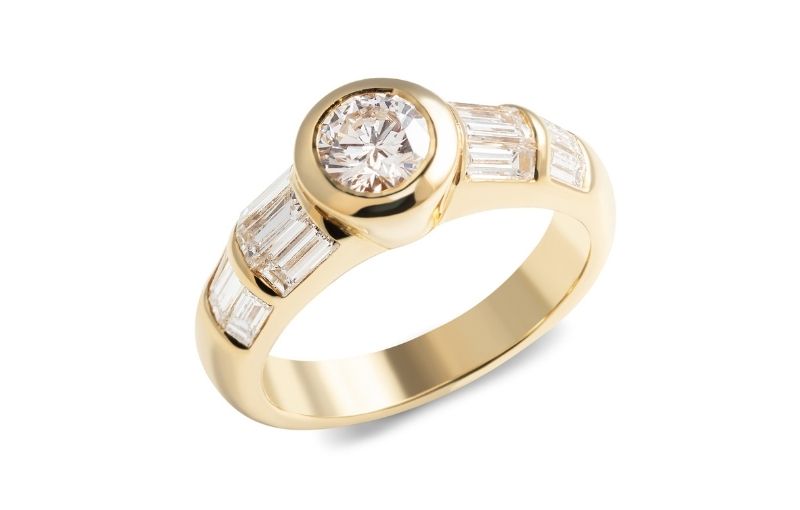 Gold ring with round brilliant cut center diamond.