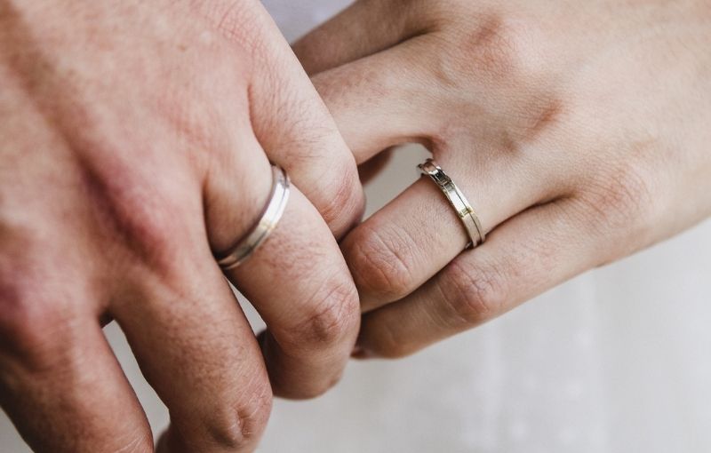 Wedding rings on joined hands.<br />
