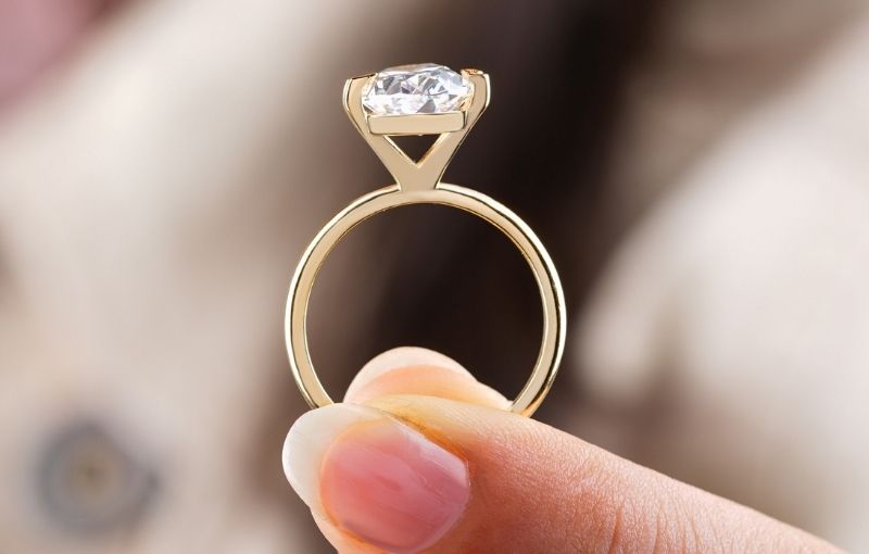 Gold solitaire engagement ring close-up.