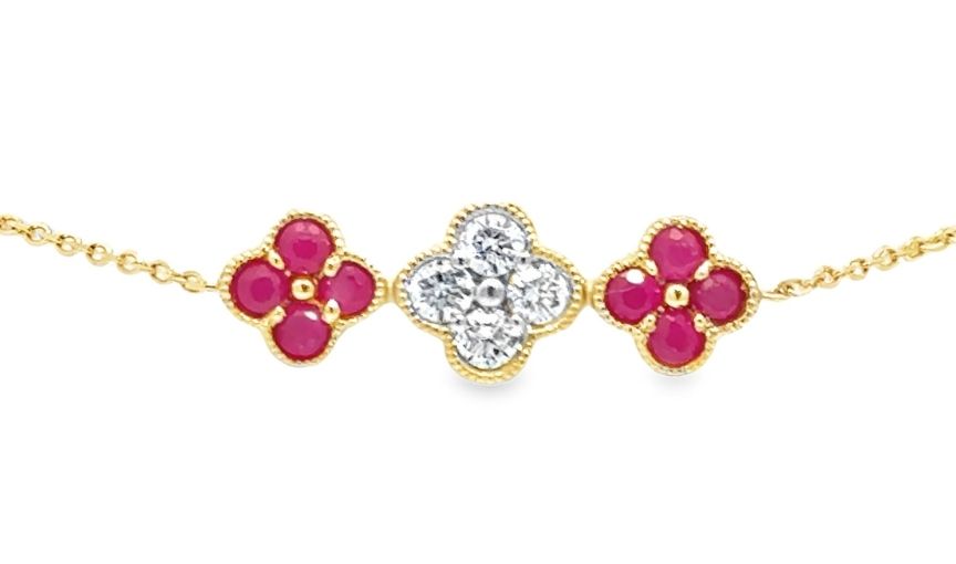 Floral gold necklace with ruby and diamond charms.
