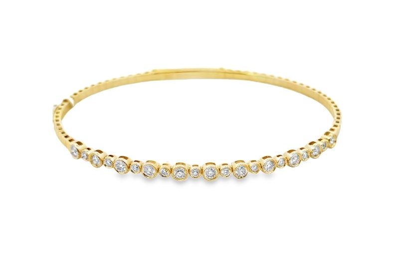 Gold tennis bracelet with bezel diamonds.
