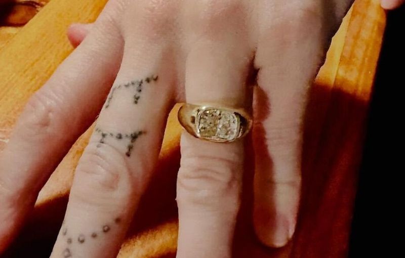 Gold ring with cushion cut diamond.