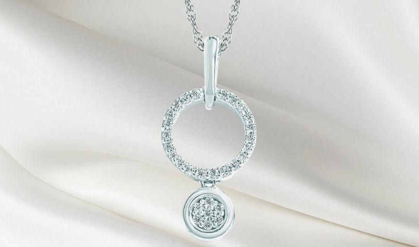 Circular diamond drop pendant necklace.