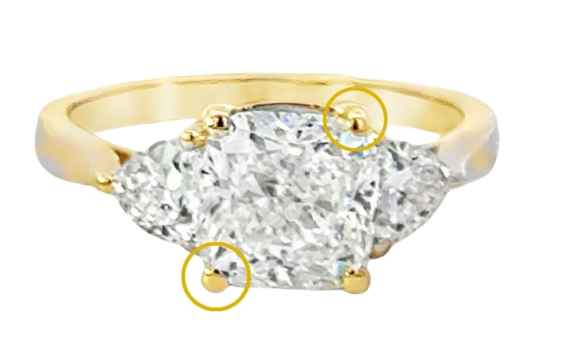 Gold three-stone diamond engagement ring.