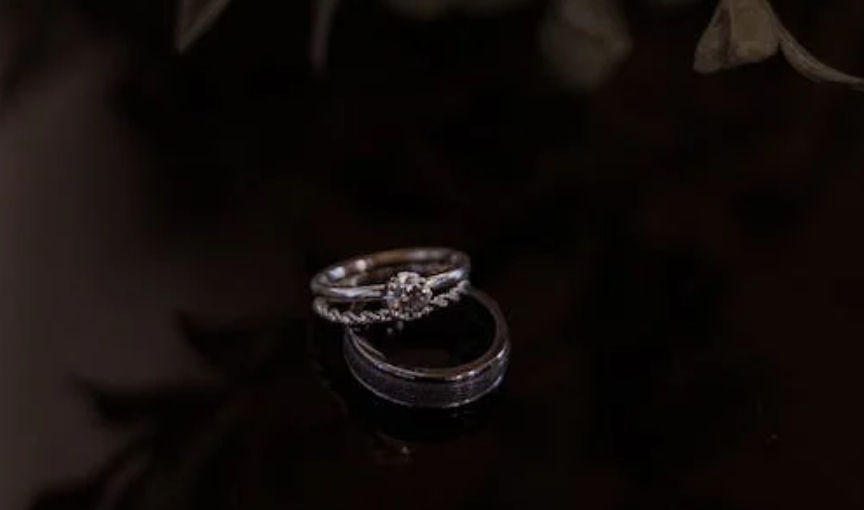 Diamond engagement ring with wedding band on dark surface