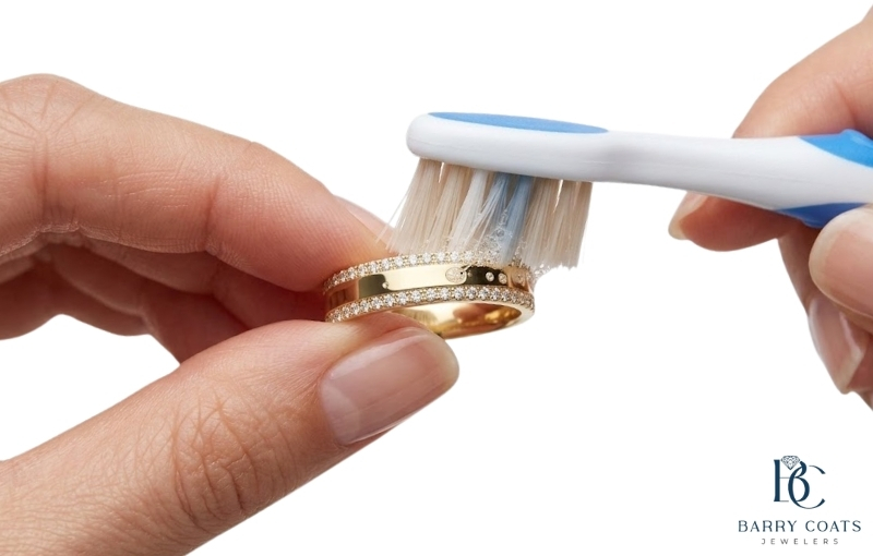 Gently brushing a diamond gold ring for cleaning White gold diamond pavé eternity ring close-up
