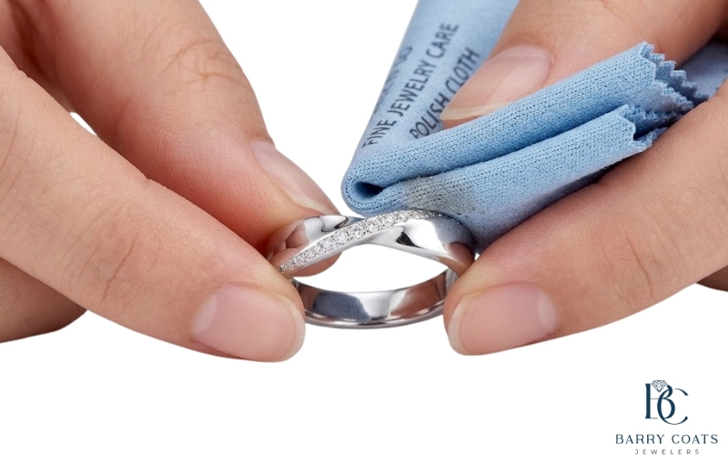 Polishing a silver diamond ring with a soft cloth White gold diamond pavé eternity ring close-up