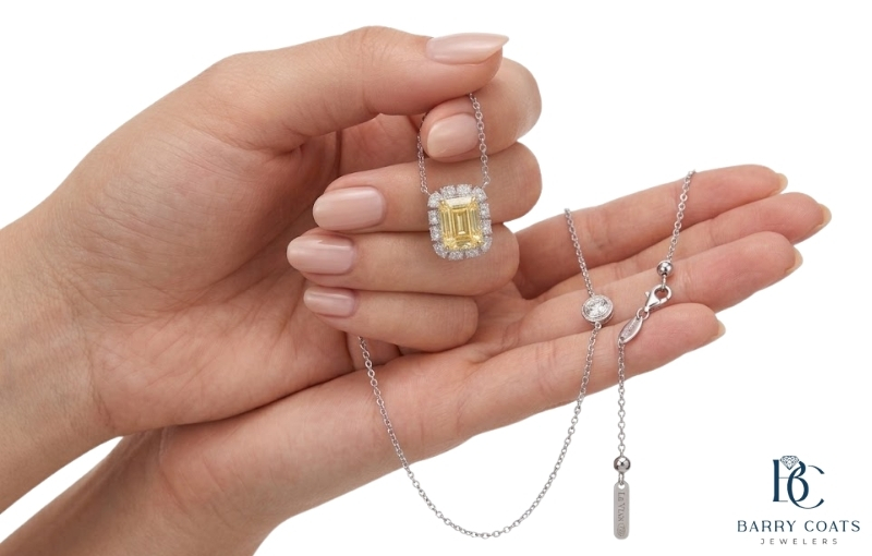 Yellow gemstone pendant necklace held in hands White gold diamond pavé eternity ring close-up